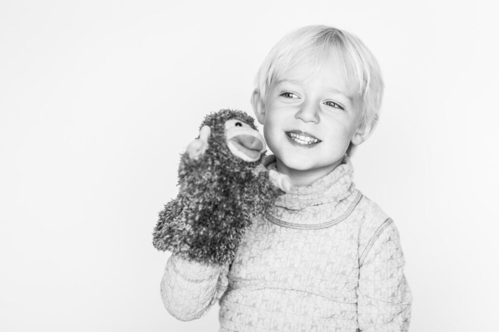 Bilder på en busig Hugo 3 år som leker med en handdocka (apa)
