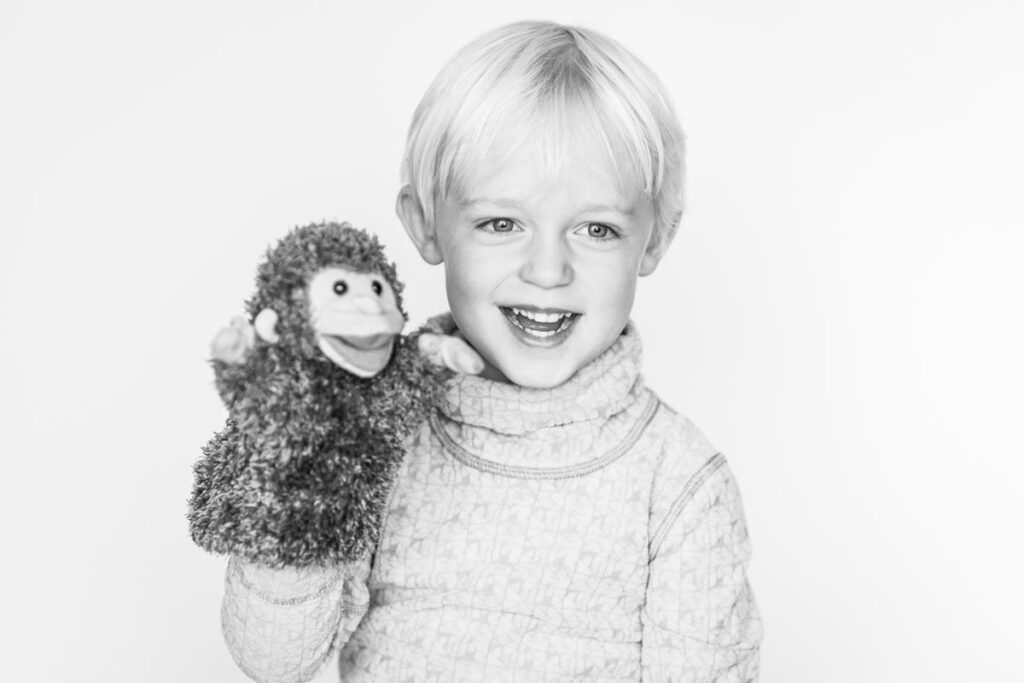 Bilder på en busig Hugo 3 år som leker med en handdocka (apa)