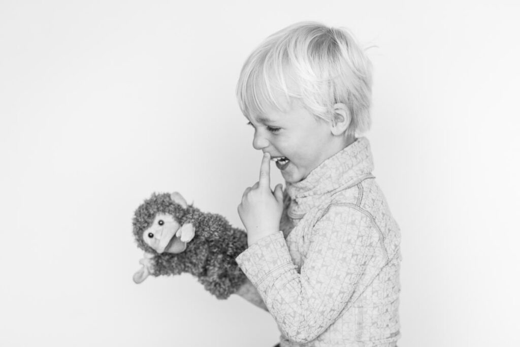 Bilder på en busig Hugo 3 år som leker med en handdocka (apa)