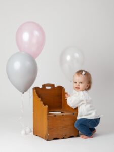 ettårig flicka med ballonger i studio