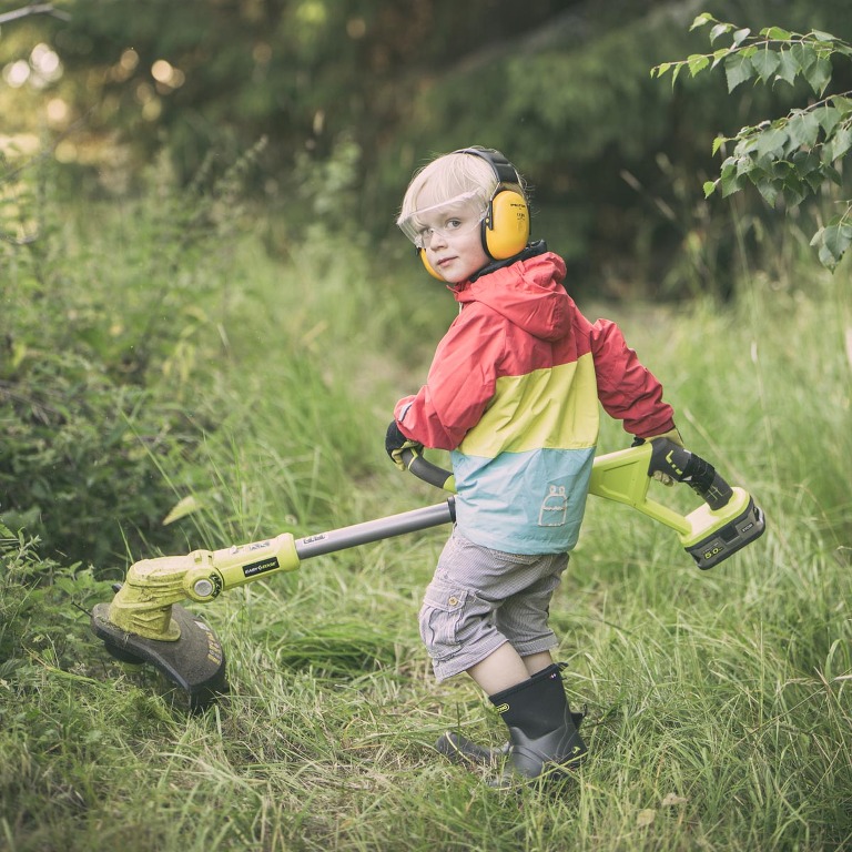 Treåriga Hugo trimmar gräs på landet